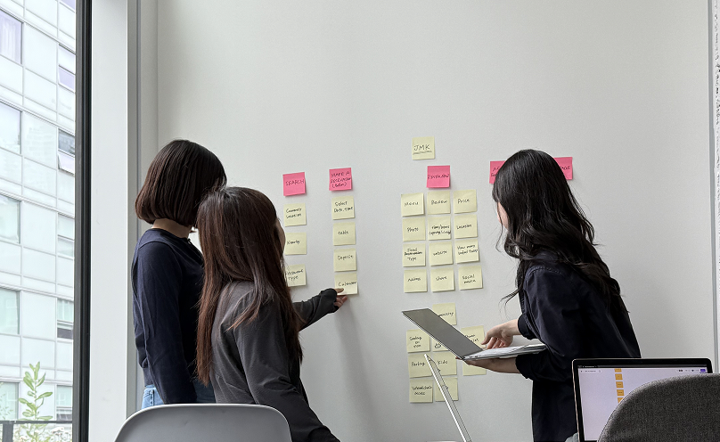 Team card-sorting session with sticky notes on a wall