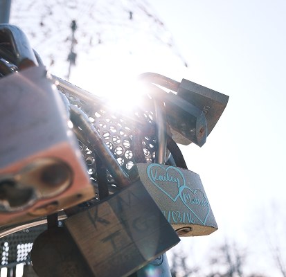 Love locks on a bridge railing, backlit