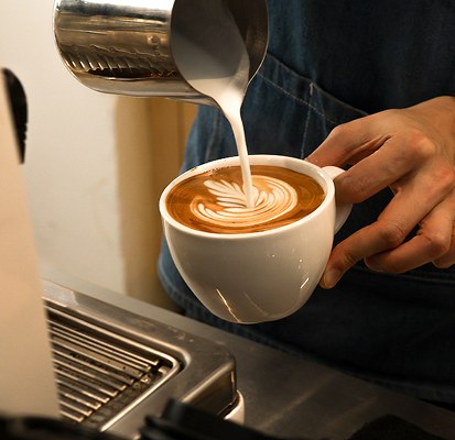 Latte art being poured into a cup