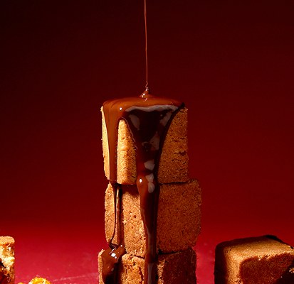 Chocolate sauce drizzled over pastry cubes